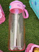 Pink Spixal drink bottle on grass background