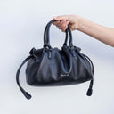 Cleo Leather handbag Black with Silver Spixal logo soft leather tote held by model
