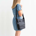 Evie Bucket Leather Crossbody Handbag Black — Model by women wearing denim dress side view | Spixal