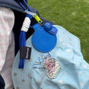 Light blue bucket hat with cartoon design, blue strap, and Spixal logo on a grassy background.