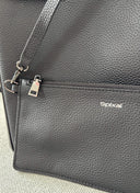 Black pebble leather bag with a visible Spixal brand logo on a light grey background